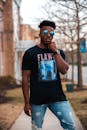 A Man in Black Shirt with Sunglasses Posing while Standing Outside