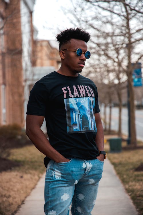 A Man in Black Shirt with Sunglasses Posing while Standing Outside