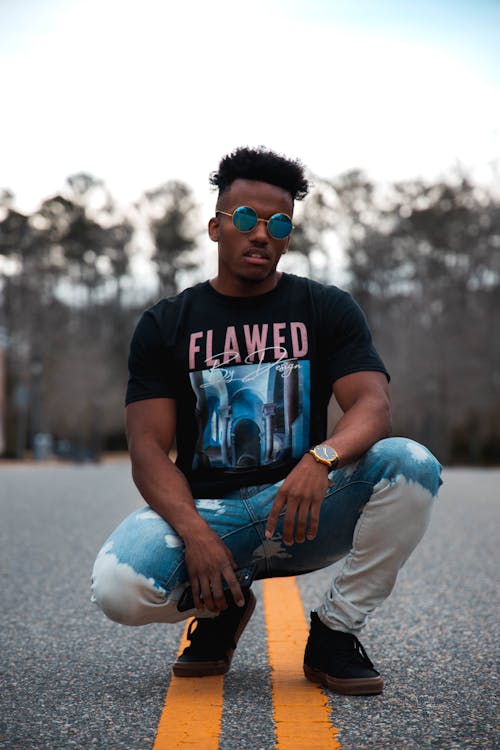 A Man in Black Shirt with Sunglasses Posing on the Road 