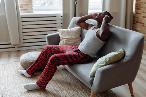 A Man with Headphones Relaxing on the Sofa