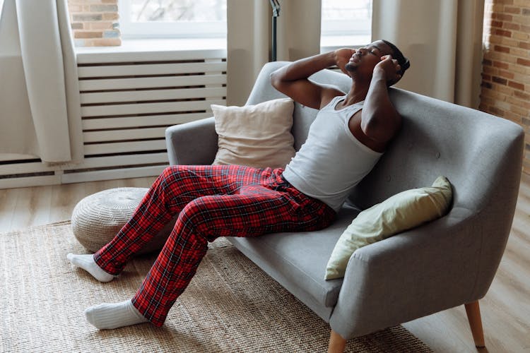 A Man With Headphones Relaxing On The Sofa