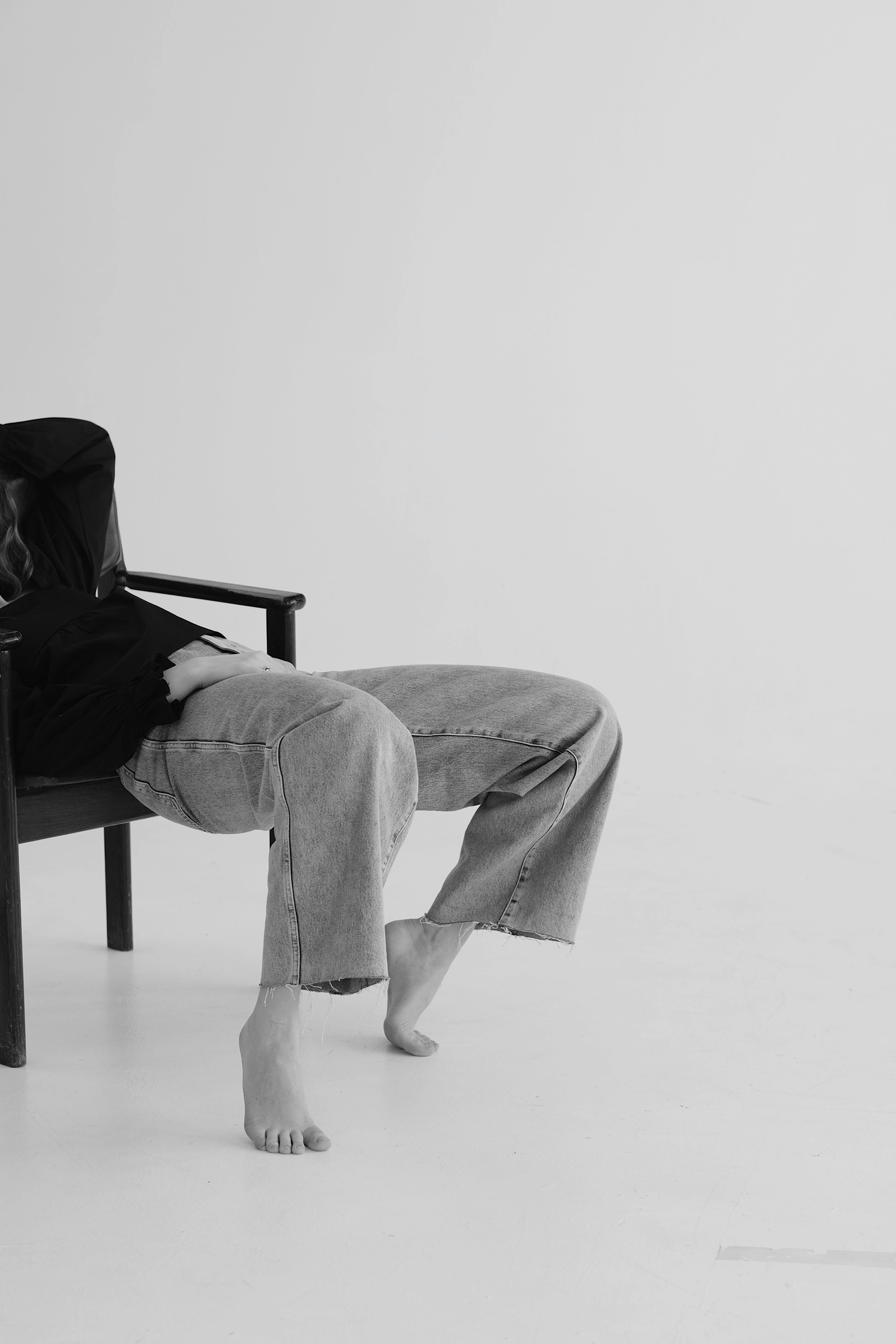 Man in Black Jacket and Gray Pants Sitting on Chair
