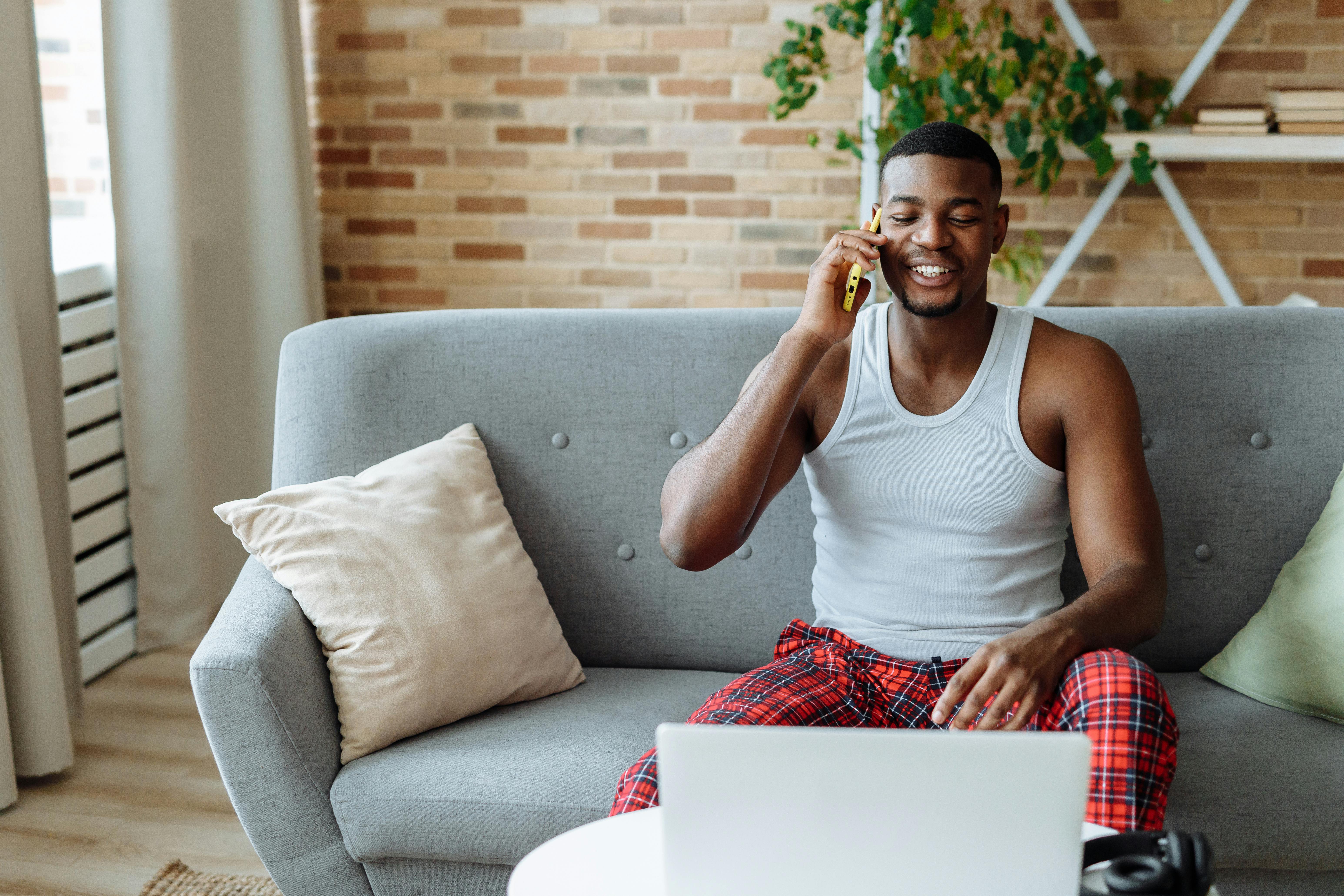 photo of a man in a white tank top talking on his cell phone