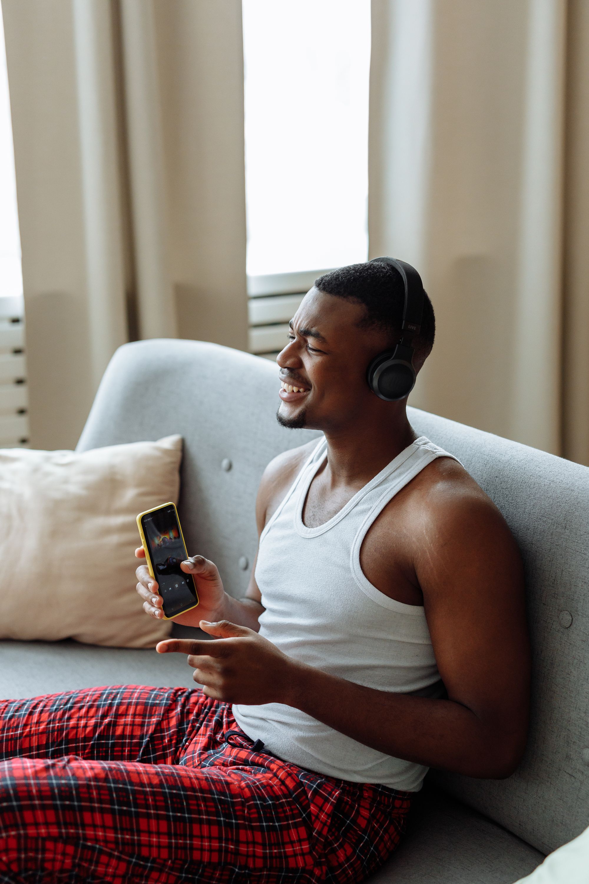Homme assis dans un canapé écoutant de la musique avec un casque