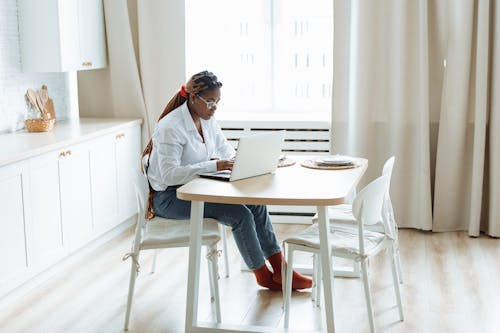 Free Photograph of a Woman in a White Dress Shirt Working on Her Laptop Stock Photo