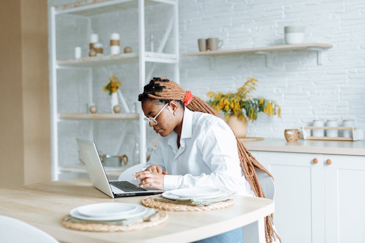 Woman Using A Laptop In The Kitchen