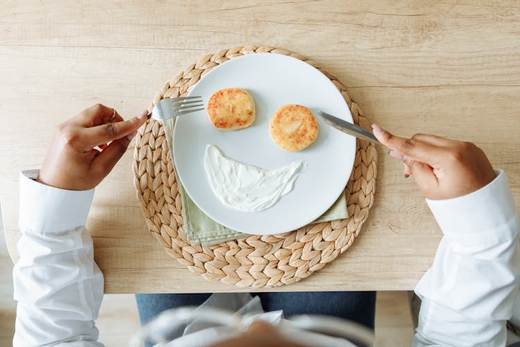 A Ceramic Plate With Pancakes And Cream Cheese