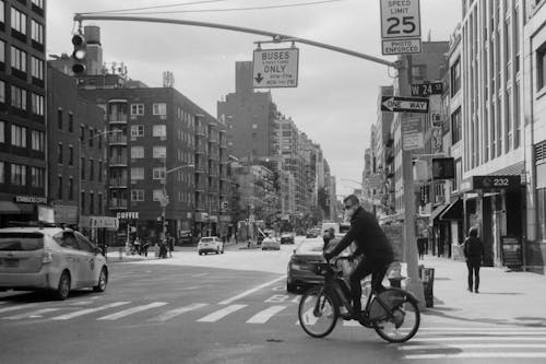 Grayscale Photo of Man Riding Motorcycle on Road