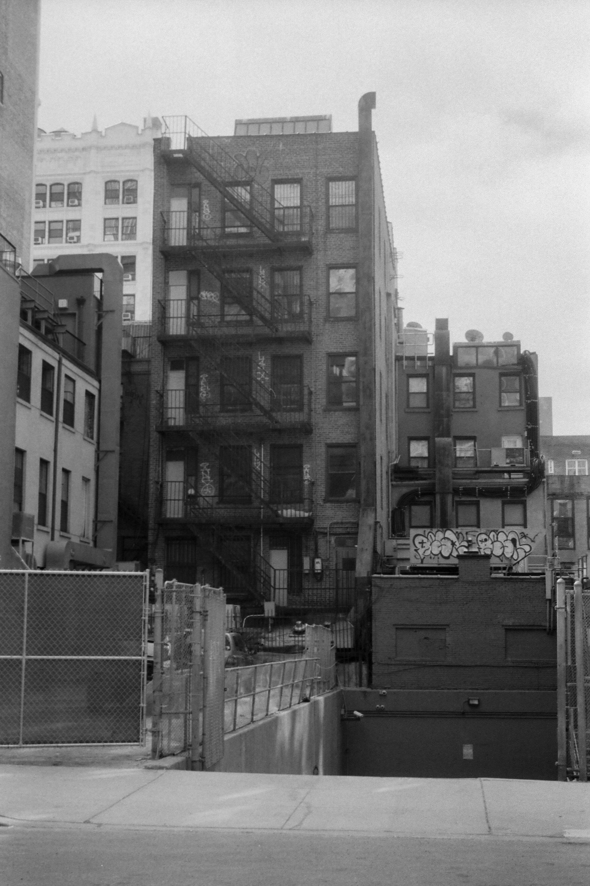 Vintage-style black and white photo capturing urban street buildings and city atmosphere.