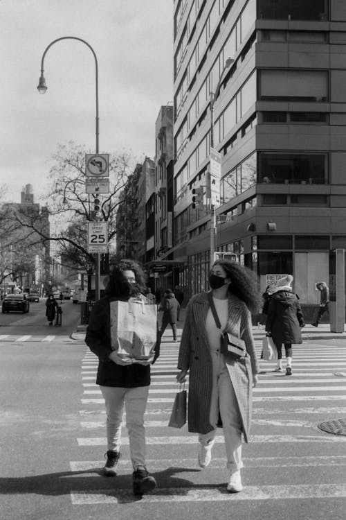 Black and White Photo of Two Women Crossing a Road