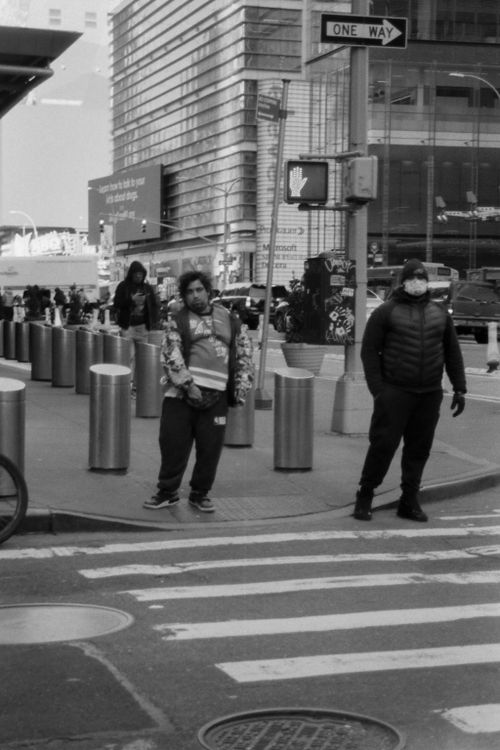 Free Black and white photo of people waiting at a city crosswalk with modern architecture. Stock Photo