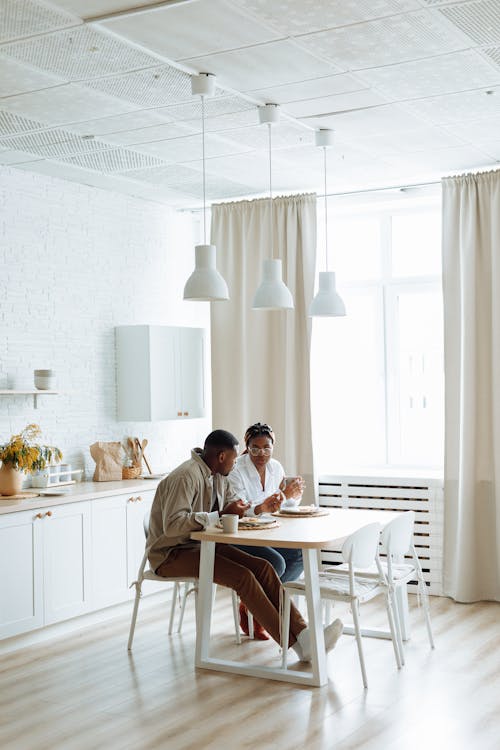 Free Man and Woman Talking While Sitting by the Table Having Breakfast  Stock Photo