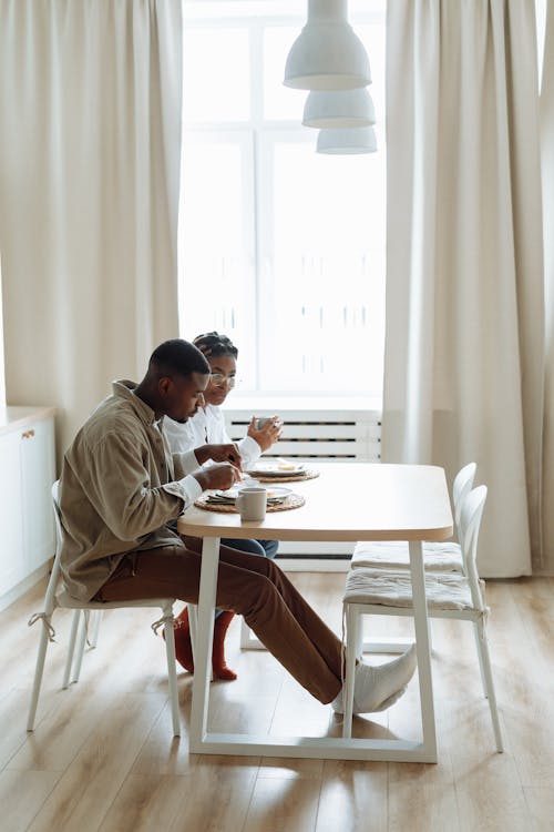Free Man and Woman Talking While Sitting by the Table Having Breakfast Stock Photo