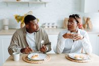 Man in White Dress Shirt Sitting Beside Woman in White Long Sleeve Shirt