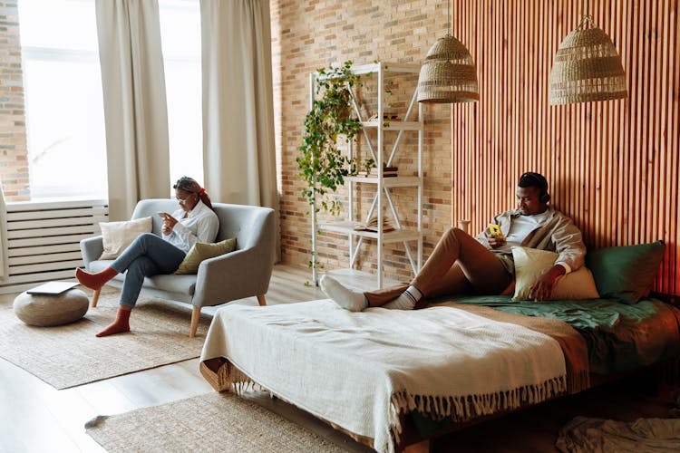 Busy Couple Using Cellphone Inside The Bedroom 