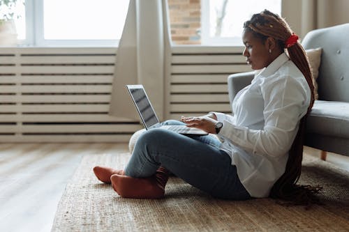 Free Photo of a Woman with Dreadlocks Sitting Working on Her Laptop Stock Photo