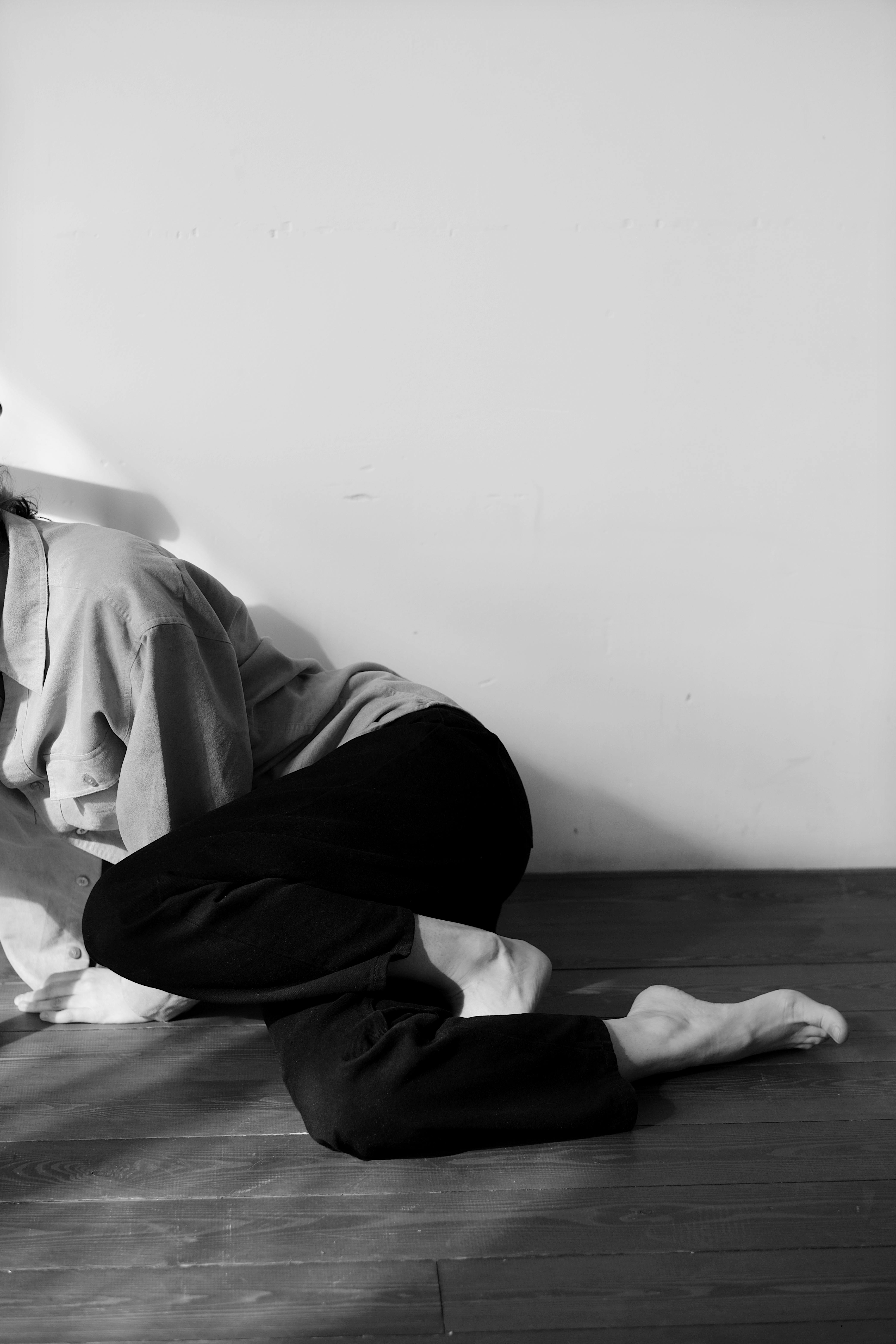 Person in White Dress Shirt and Black Pants Sitting on Bed