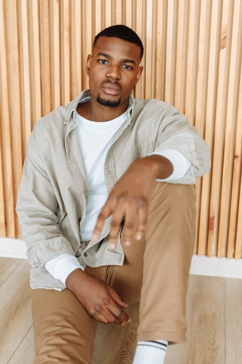 Man in a Gray Long Sleeve Polo Looking at the Camera while Sitting on the Floor