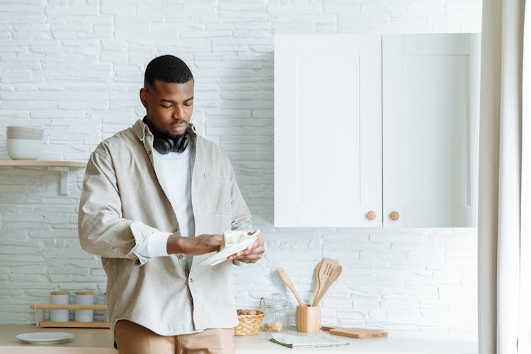 A Man Wiping The Ceramic Plate