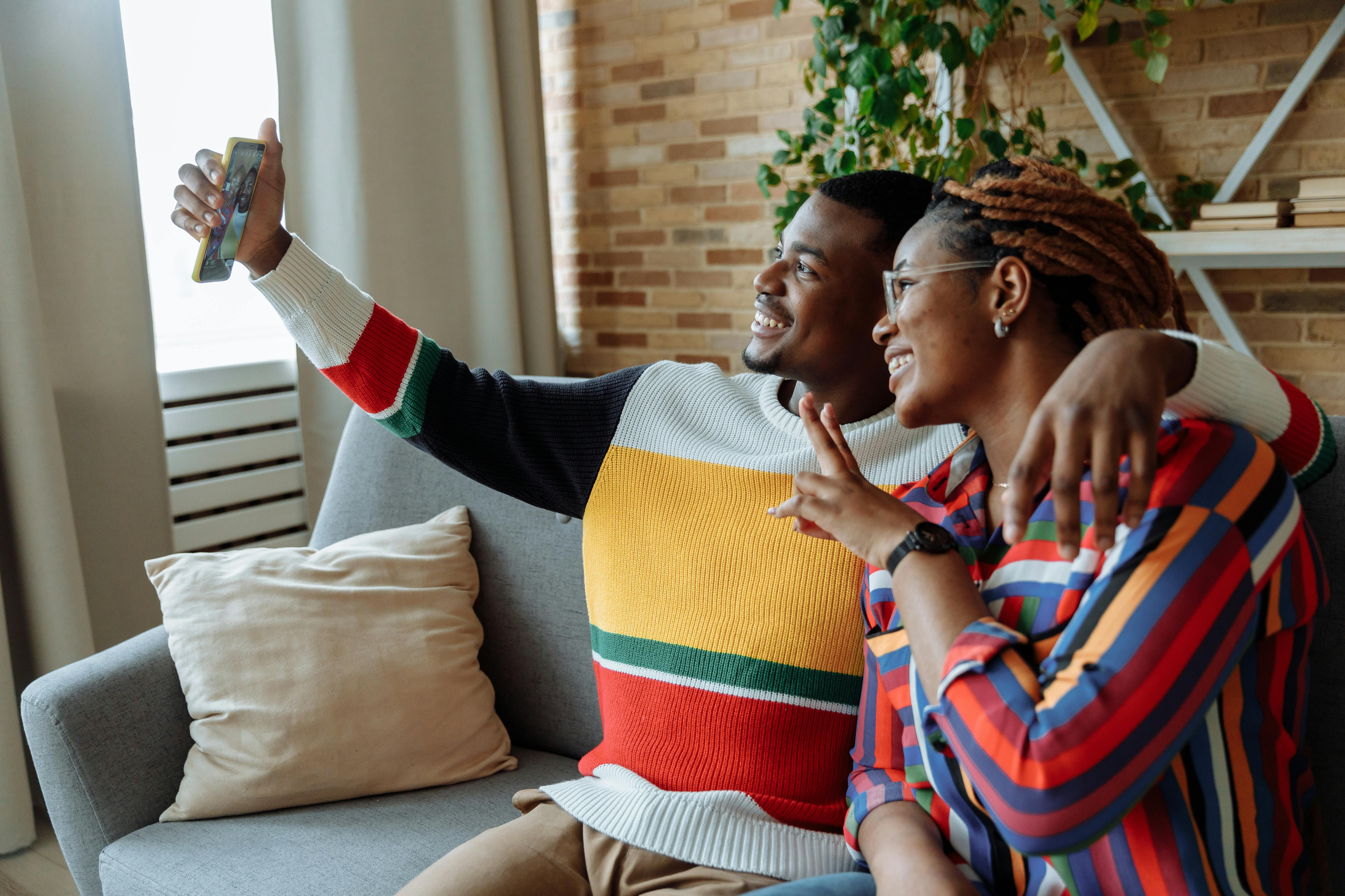 photo of a man using a cell phone to take a photo with a woman