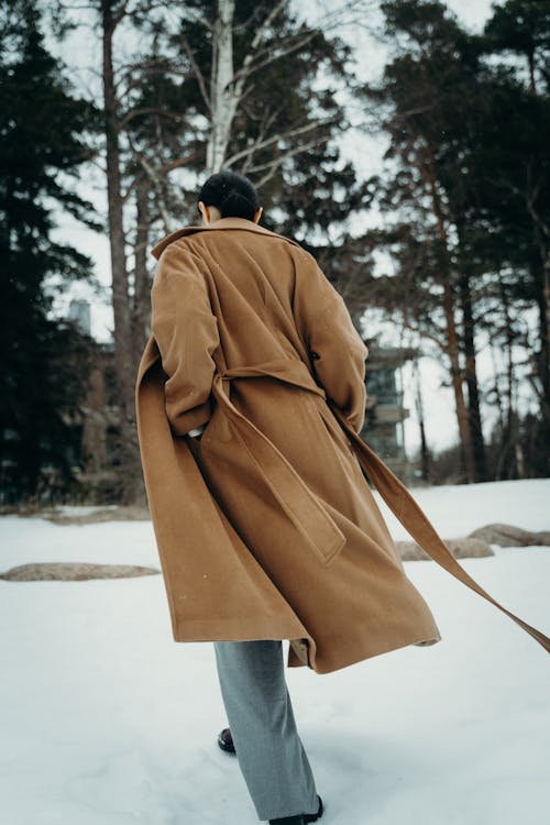 Back View of a Woman in a Beige Coat Walking Away