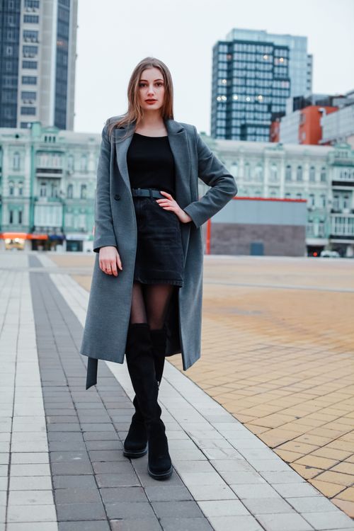 Free Elegant woman posing in a grey coat with urban Kyiv backdrop, showcasing modern fashion. Stock Photo
