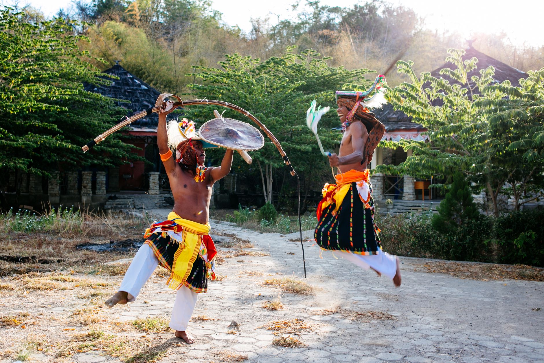 Traditional dancers in colorful costumes performing a warrior dance in Nusa Tenggara, Indonesia.