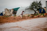 Child Holding a Cane Walking on Dirt Road