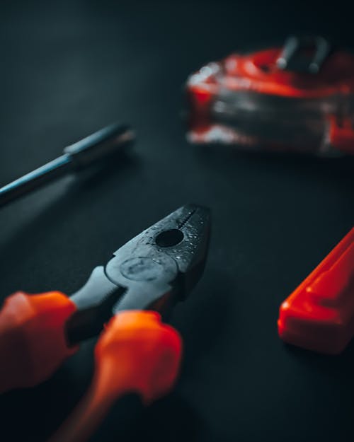 Pliers and instruments on black surface