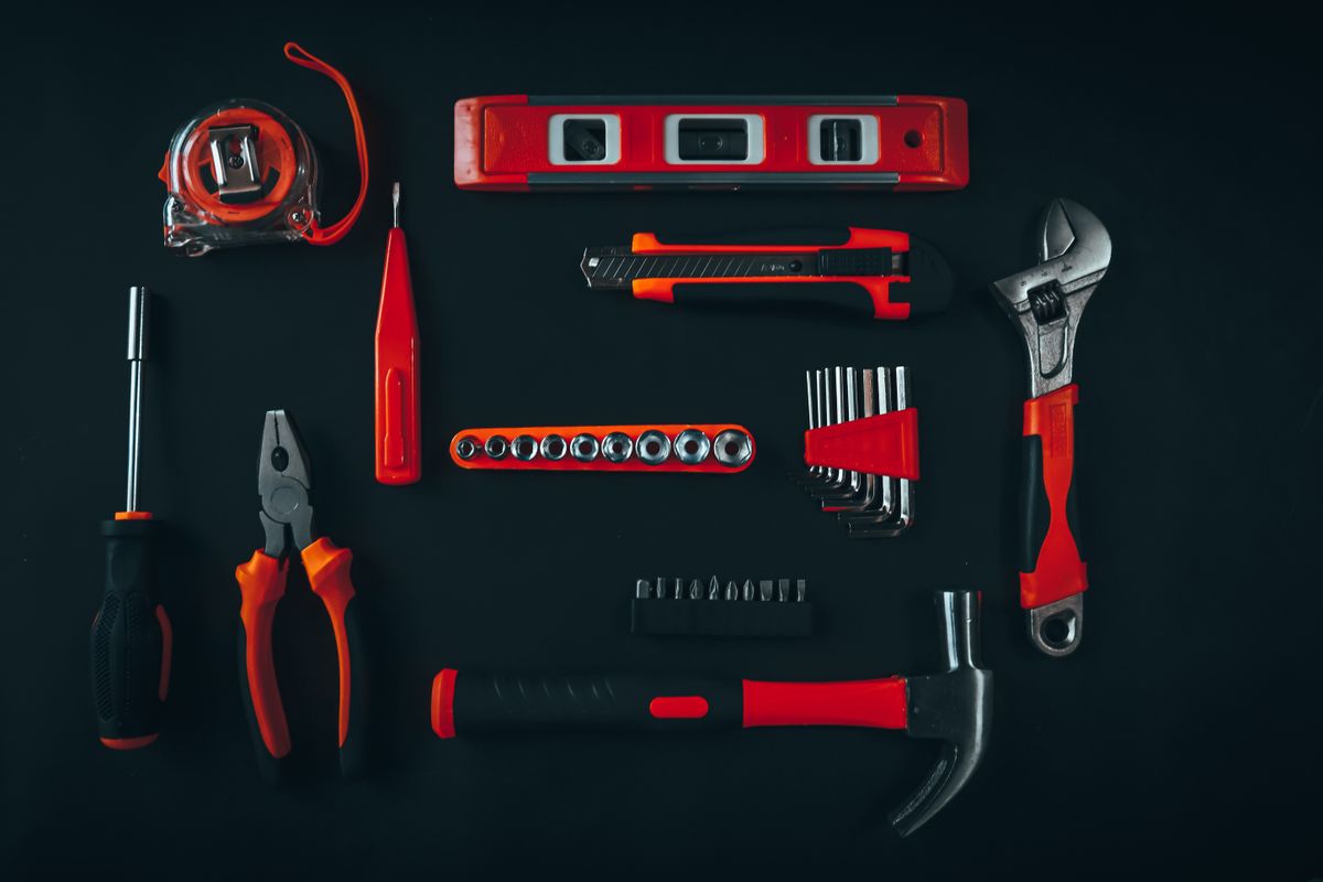 Top-down view of repair tools on a dark surface