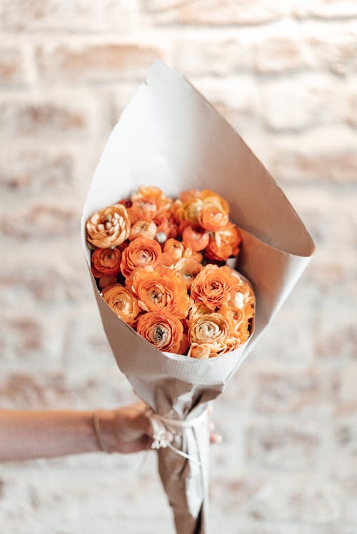 Faceless person with orange roses