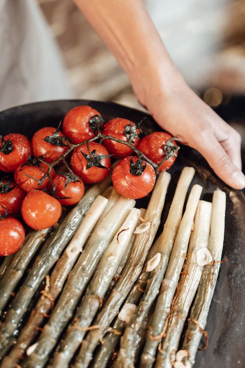 Free Close-up of roasted asparagus and vine tomatoes on a platter, food photography Stock Photo