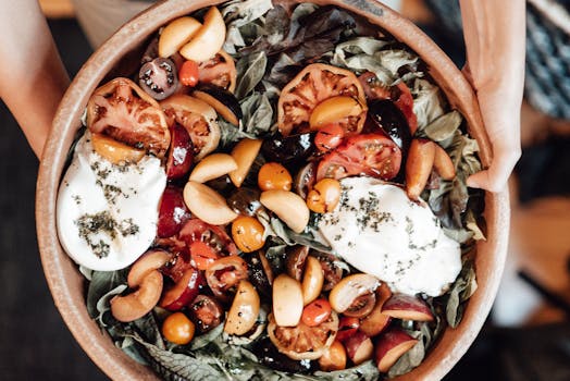 Vibrant salad of tomatoes, plums, and mozzarella in a ceramic bowl.