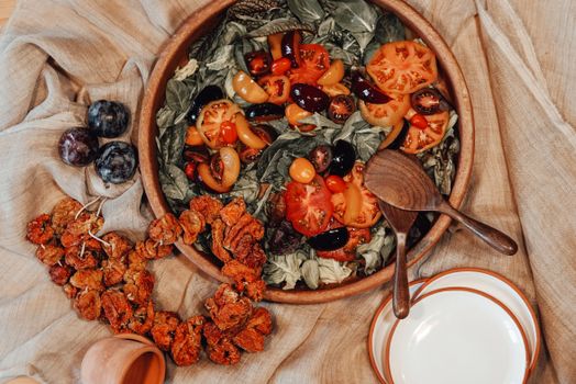 Delight in a colorful rustic vegetable salad featuring fresh tomatoes, olives, and leafy greens.