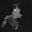 Tattooed stylish woman staring through glass with duct tape