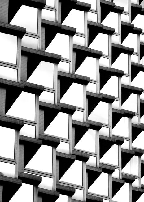 Black and white of facade of contemporary multistory building with cube windows as abstract background