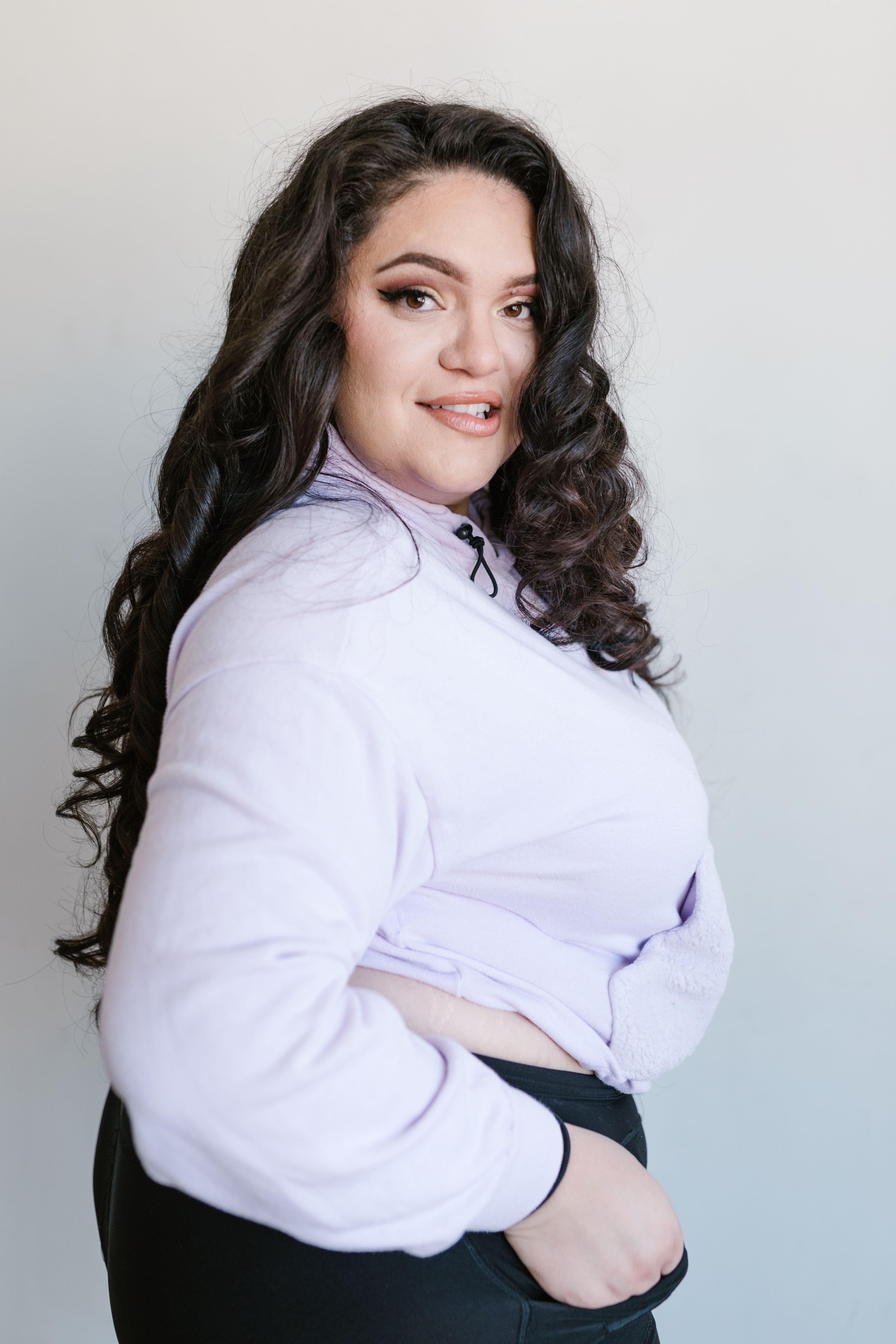 Plus size model posing in stylish attire, promoting body positivity and modern fashion.