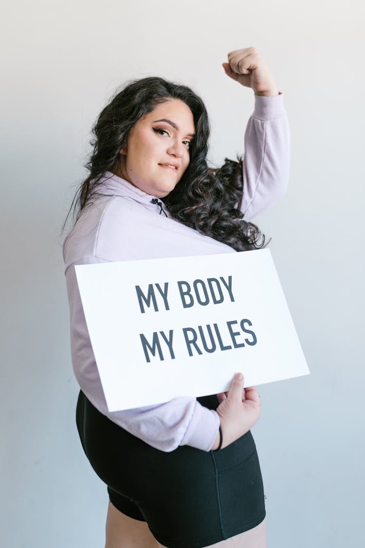 Woman Holding A Sign With Her Fist Up