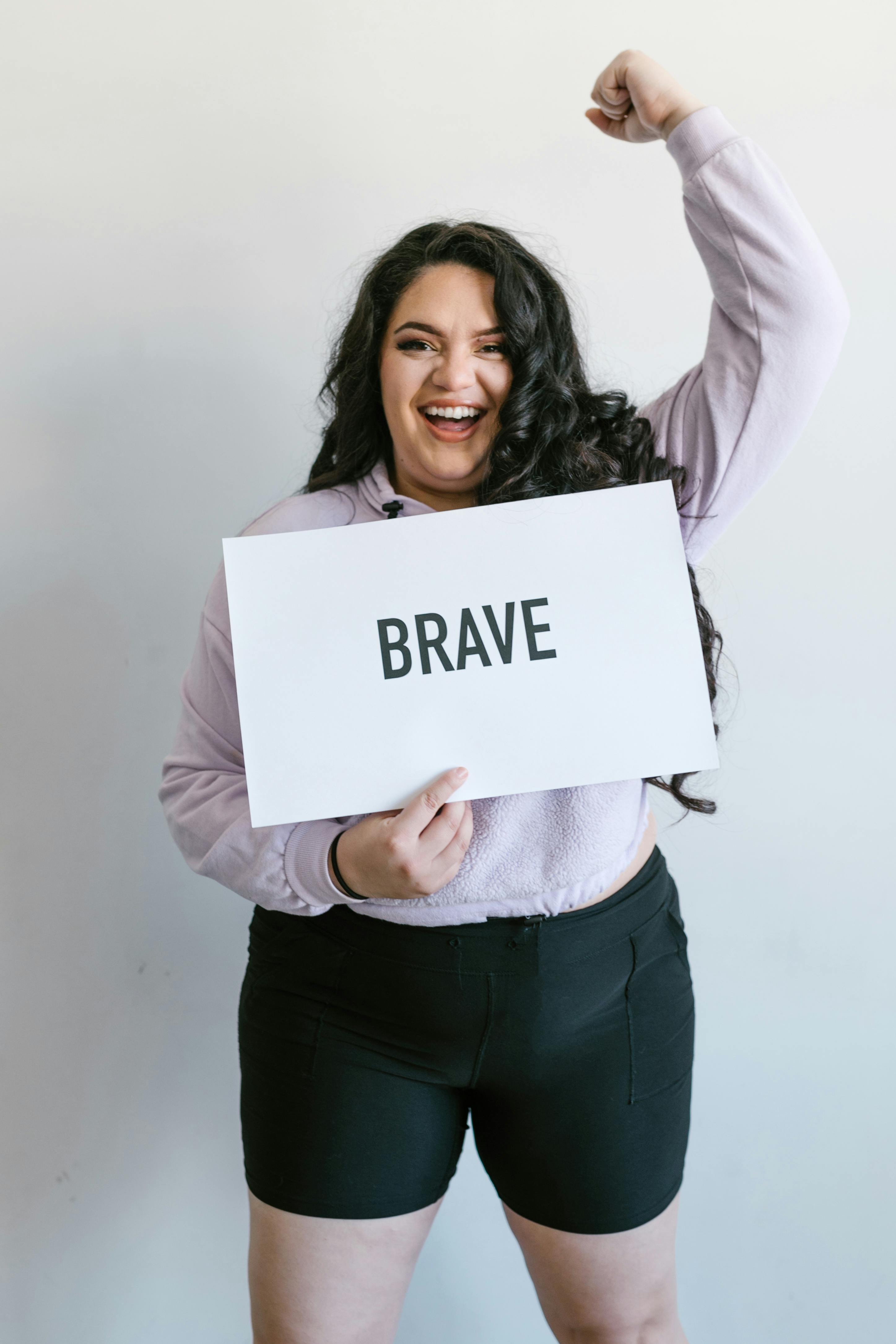 a woman holding a brave sign