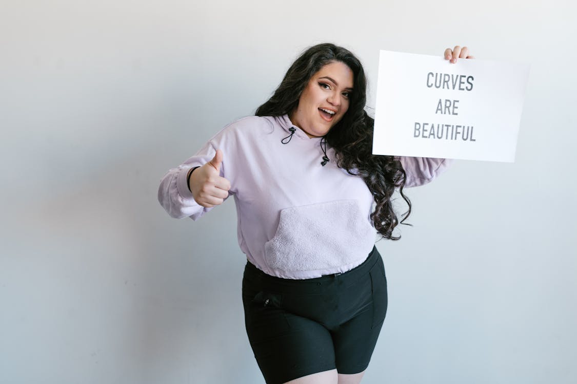 Free Confident Woman Holding a Sign Stock Photo:Curves are beautiful