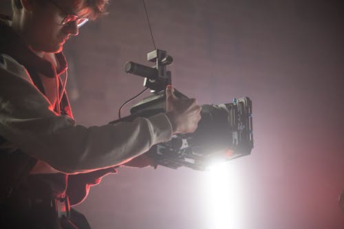 Man in Sweater Holding a Black Video Camera