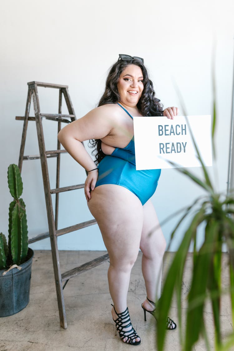 Woman Wearing A Bathing Suit Holding A Sign