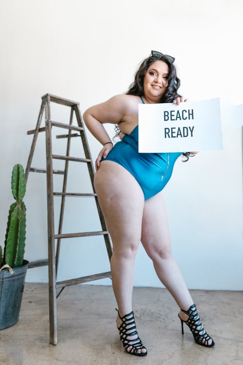 Woman in Blue Swimsuit Holding a Sign