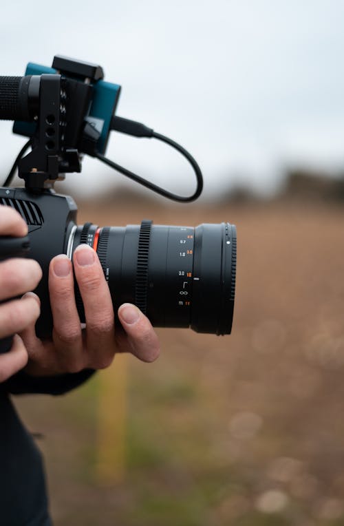 A Person Holding a Black Dslr Camera