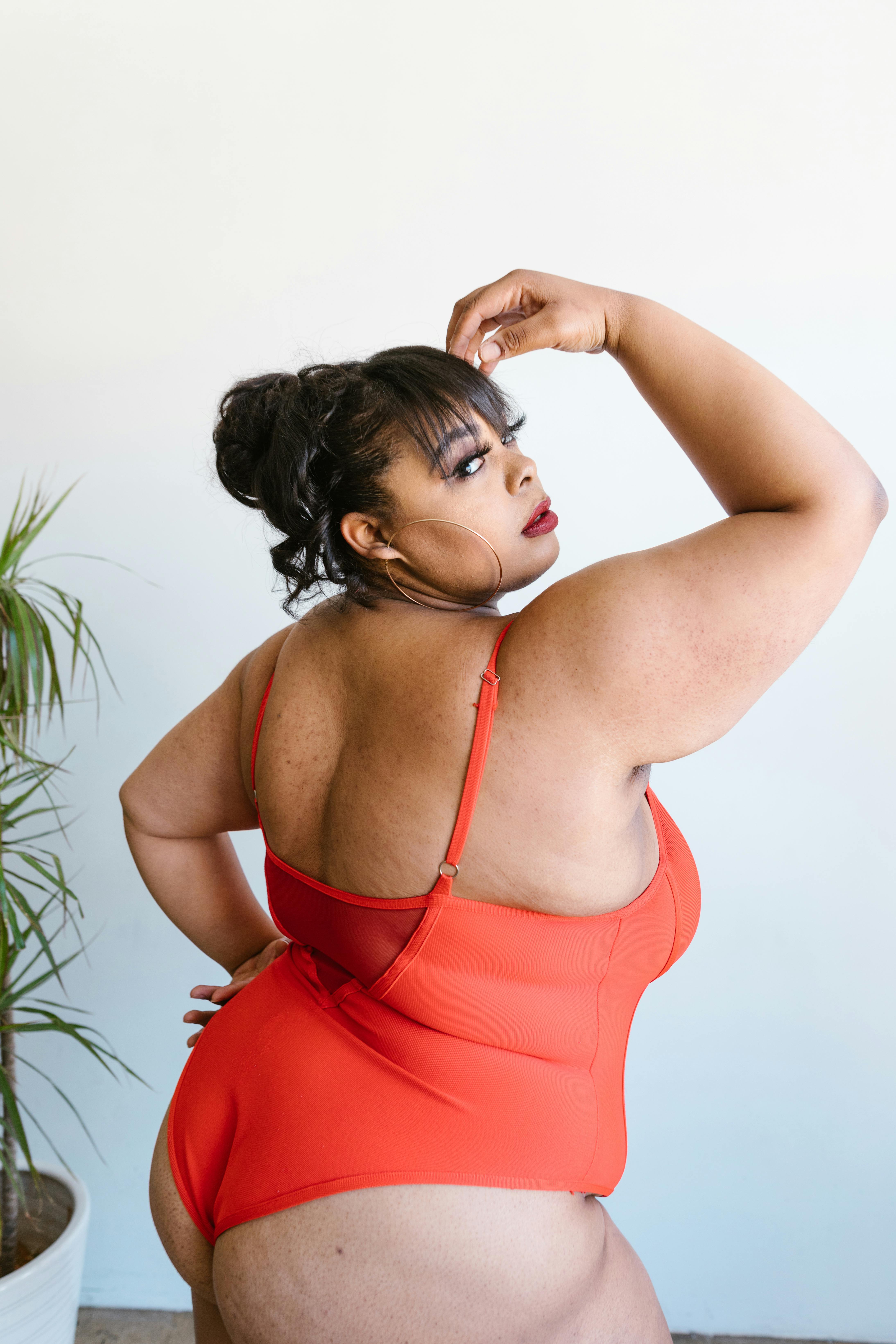 woman wearing a red bathing suit with hand on forehead