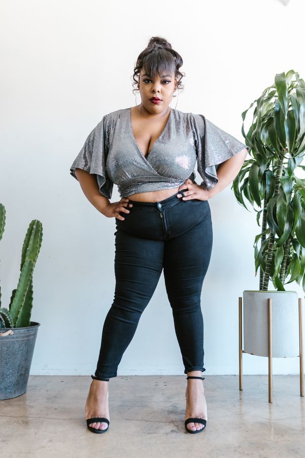 Woman in black skinny jeans with a silver sparkle top