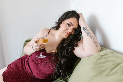 Woman  in Maroon Dress Holding a Drink