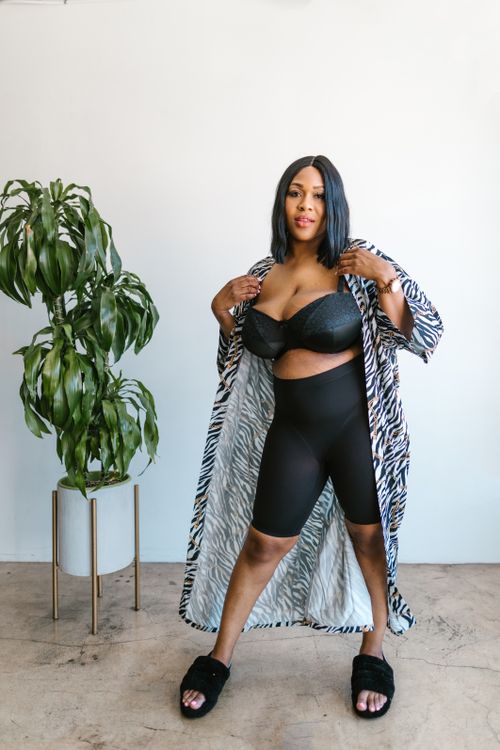 Free Plus size black woman posing confidently in zebra print robe indoors. Stock Photo