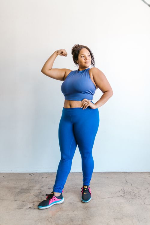 Free Strong and confident woman in activewear posing indoors, showcasing body positivity and fitness. Stock Photo