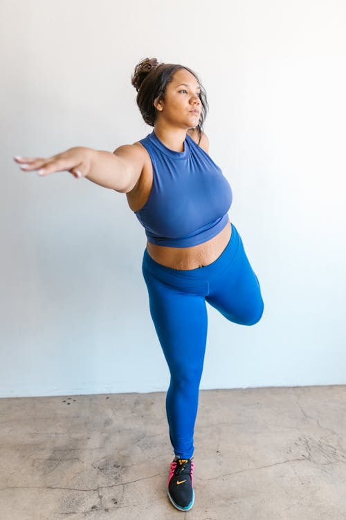 Woman in Blue Sports Bra and Blue Leggings Exercising